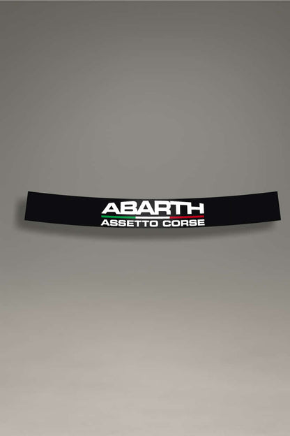 Parasol de vinilo negro con el logotipo de Abarth y el texto 'Assetto Corse' en blanco. Un accesorio de competición de MOA-Grafics para personalizar coches Fiat y proteger el interior.