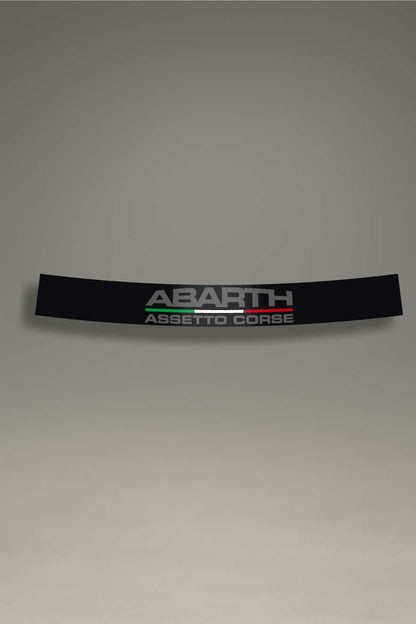 Parasol de vinilo negro con el logo Abarth y el texto 'Assetto Corse' recortado (transparente). Un accesorio de competición de MOA-Grafics para personalizar coches Fiat y crear un efecto visual único en el parabrisas.