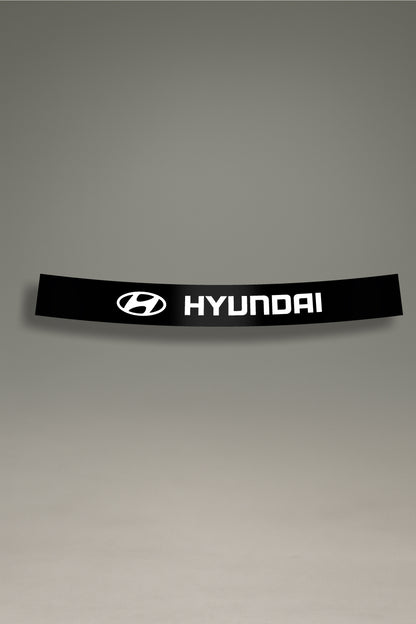 Parasol de vinilo negro con el logotipo oficial de Hyundai en blanco. Un accesorio de MOA-Grafics para personalizar y proteger el parabrisas de tu vehículo.