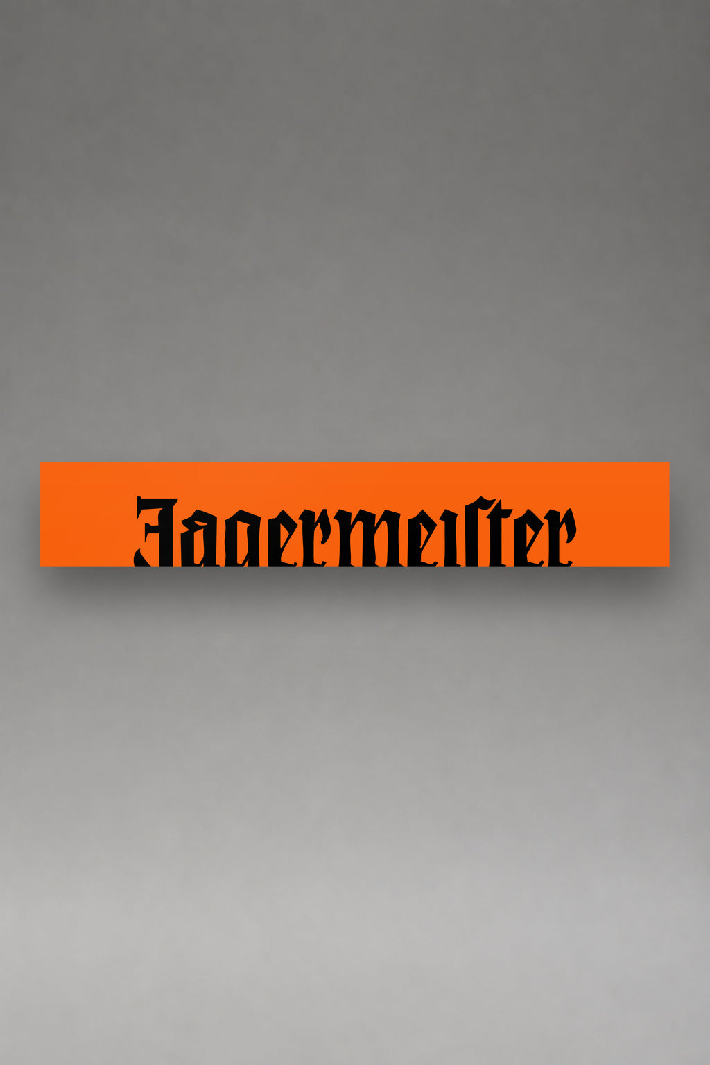 Parasol de vinilo Jagermeister naranja con el lettering gotico de la marca en negro, la tira entera de 150 x 25 cm vista de frente, de MOA-Grafics.