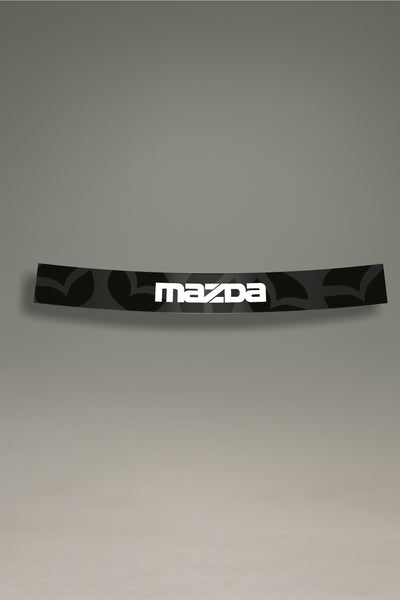 Parasol de vinilo con un patrón del emblema de Mazda en gris oscuro y el logotipo en blanco. Un accesorio de diseño de MOA-Grafics para personalizar y proteger el parabrisas.

