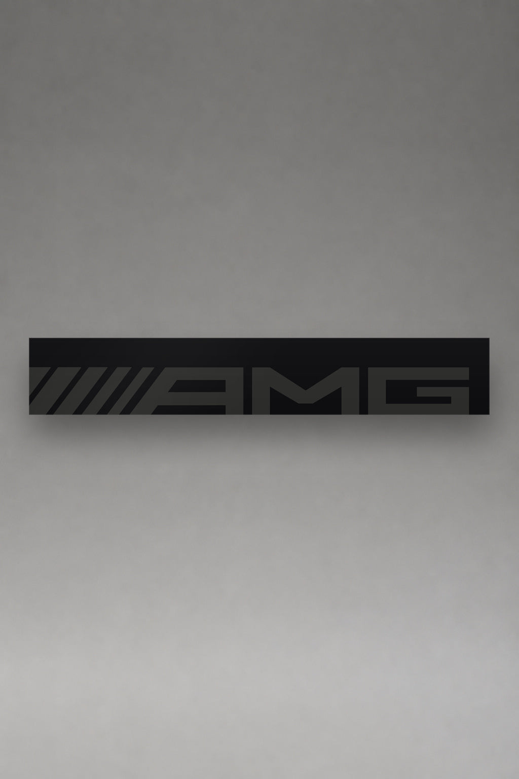 Parasol de vinilo Mercedes-AMG negro con el lettering AMG en gris a lo ancho de la tira, la pieza entera vista de frente, de MOA-Grafics.
