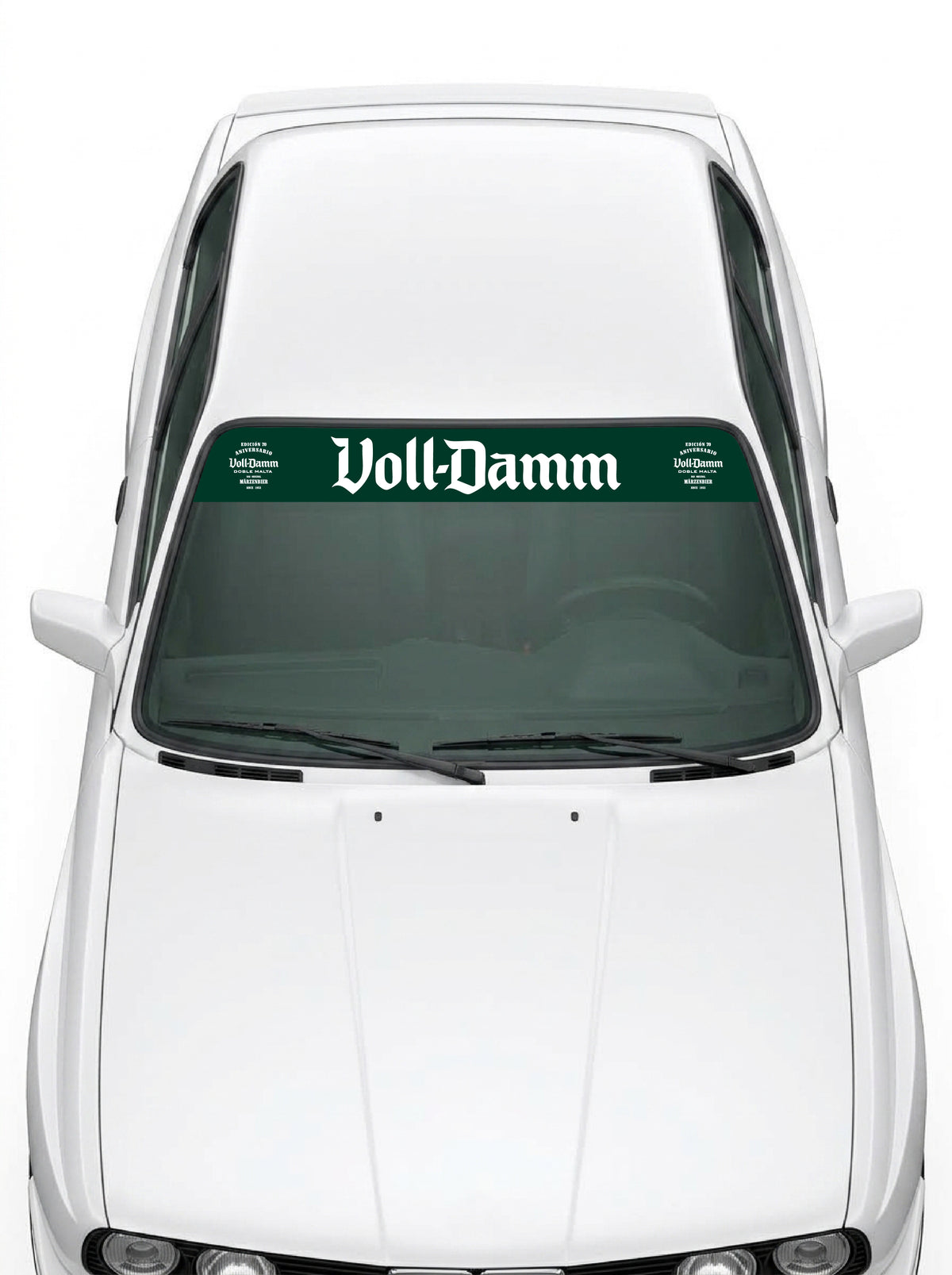Coche con el parasol de vinilo Voll-Damm verde con el lettering en blanco y los sellos de la edicion 70 aniversario a los dos lados instalado en el parabrisas