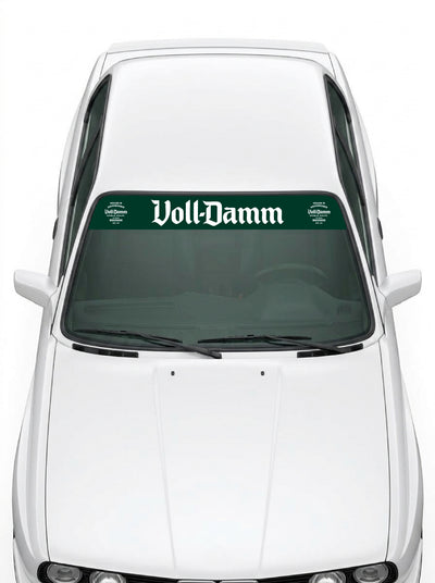 Coche con el parasol de vinilo Voll-Damm verde con el lettering en blanco y los sellos de la edicion 70 aniversario a los dos lados instalado en el parabrisas