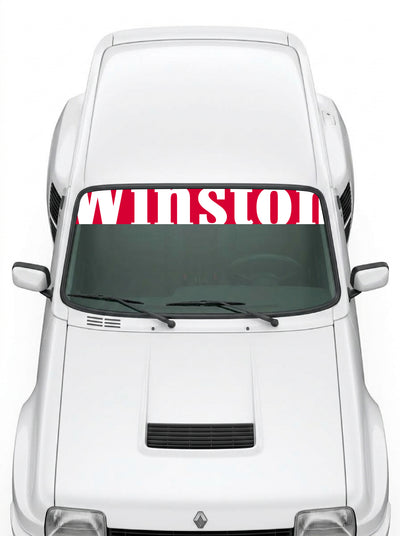 Coche con el parasol de vinilo Winston rojo con el lettering WINSTON en blanco y tipografia de bloques instalado en el parabrisas