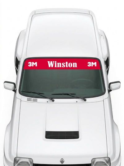 Coche con el parasol de vinilo Winston rojo con el lettering Winston en blanco y los distintivos 3M a los dos lados instalado en el parabrisas
