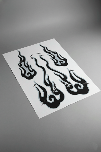 Pliego de vinilos del kit Llamas Nubladas en tonos gris y blanco, visto en mesa de estudio. Producto de alta calidad listo para instalar en vehículos.
