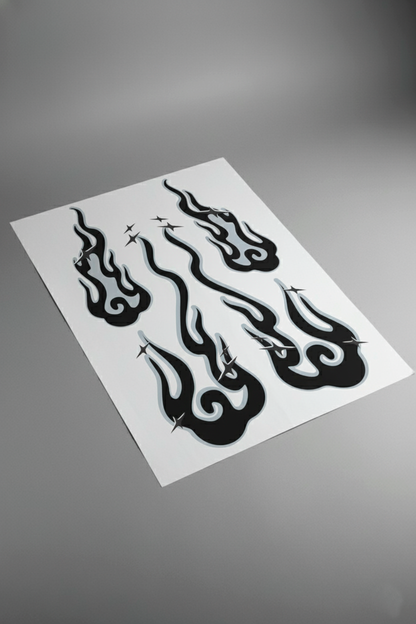 Pliego de vinilos del kit Llamas Nubladas en tonos gris y blanco, visto en mesa de estudio. Producto de alta calidad listo para instalar en vehículos.