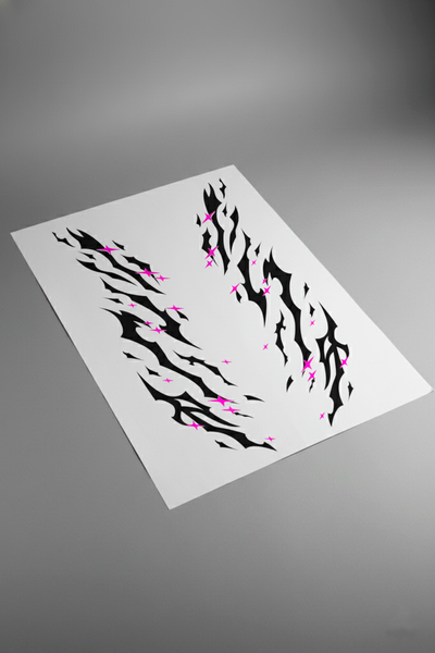 Pliego de vinilos del kit Star Tribal en negro y rosa magenta, visto en perspectiva sobre superficie gris. Kit de personalización para coches.