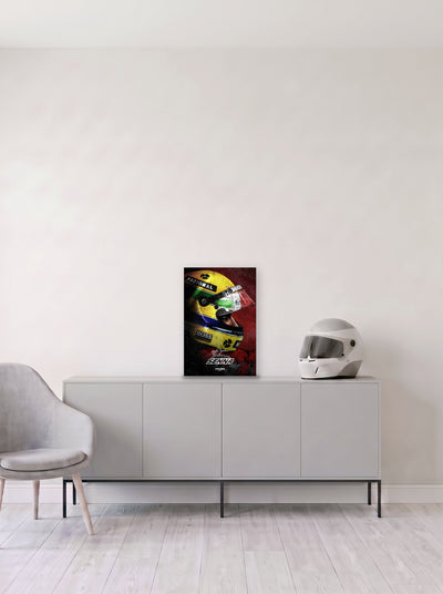 Poster del casco de Ayrton Senna sobre fondo rojo, en medida 33,3 x 50 cm, apoyado sobre un aparador gris junto a un casco de competicion, decoracion racing de MOA-Grafics.