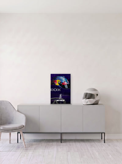 Poster del casco de Sebastian Vettel sobre fondo azul, en medida 33,3 x 50 cm, apoyado sobre un aparador gris junto a un casco de competicion, decoracion racing de MOA-Grafics.