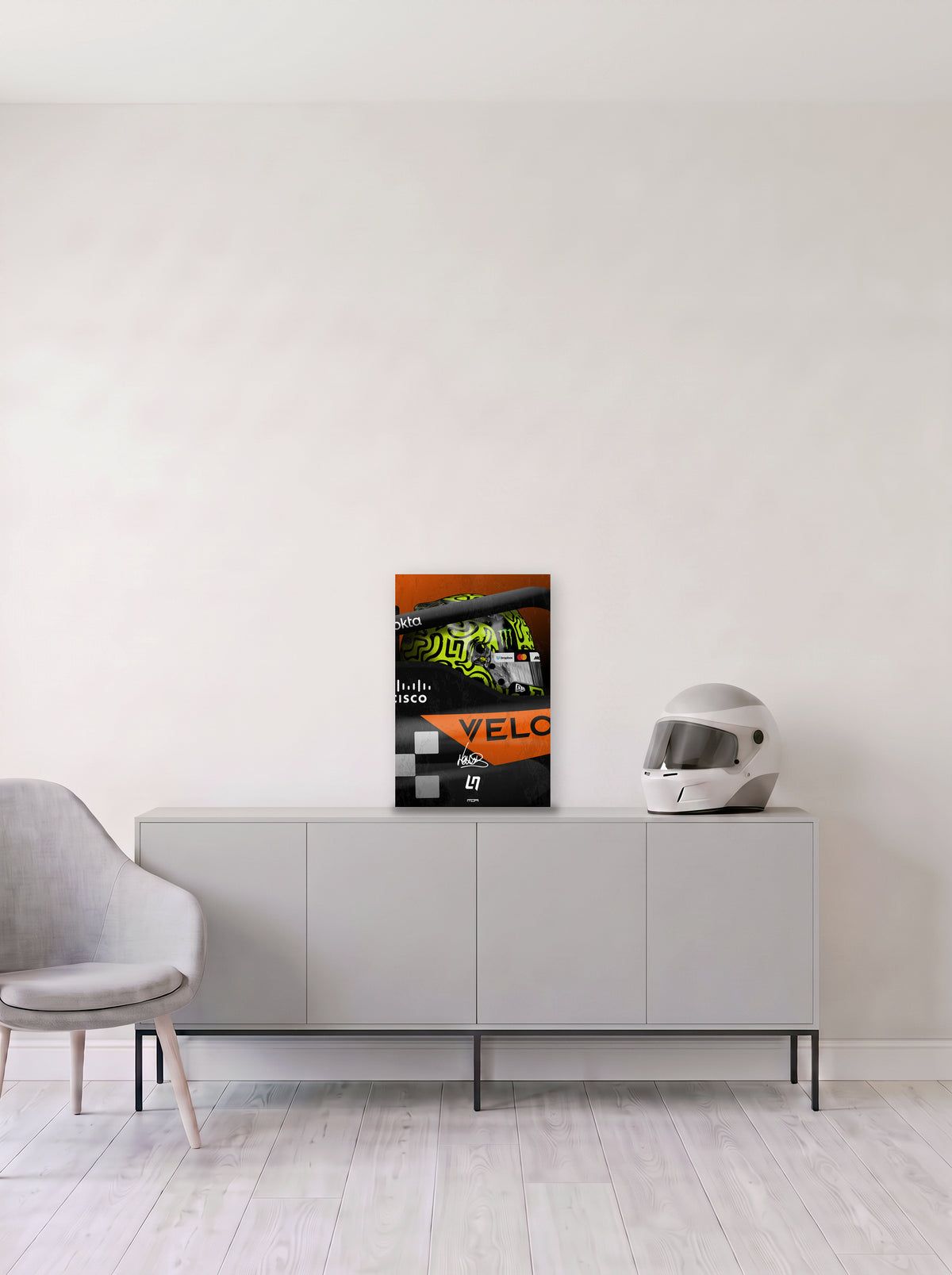 Poster del casco de Lando Norris asomando del cockpit del McLaren, en medida 33,3 x 50 cm, apoyado sobre un aparador gris junto a un casco de competicion, decoracion racing de MOA-Grafics.