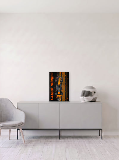 Poster del McLaren de Lando Norris con su nombre en vertical sobre franjas naranjas, en medida 33,3 x 50 cm, apoyado sobre un aparador gris junto a un casco de competicion, decoracion racing de MOA-Grafics.