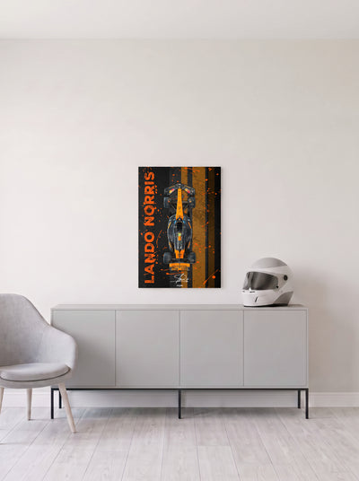 Poster del McLaren de Lando Norris con su nombre en vertical sobre franjas naranjas, en medida 46,7 x 70 cm, colgado en la pared clara de un salon, sobre un aparador gris con un casco de competicion al lado, decoracion racing de MOA-Grafics.