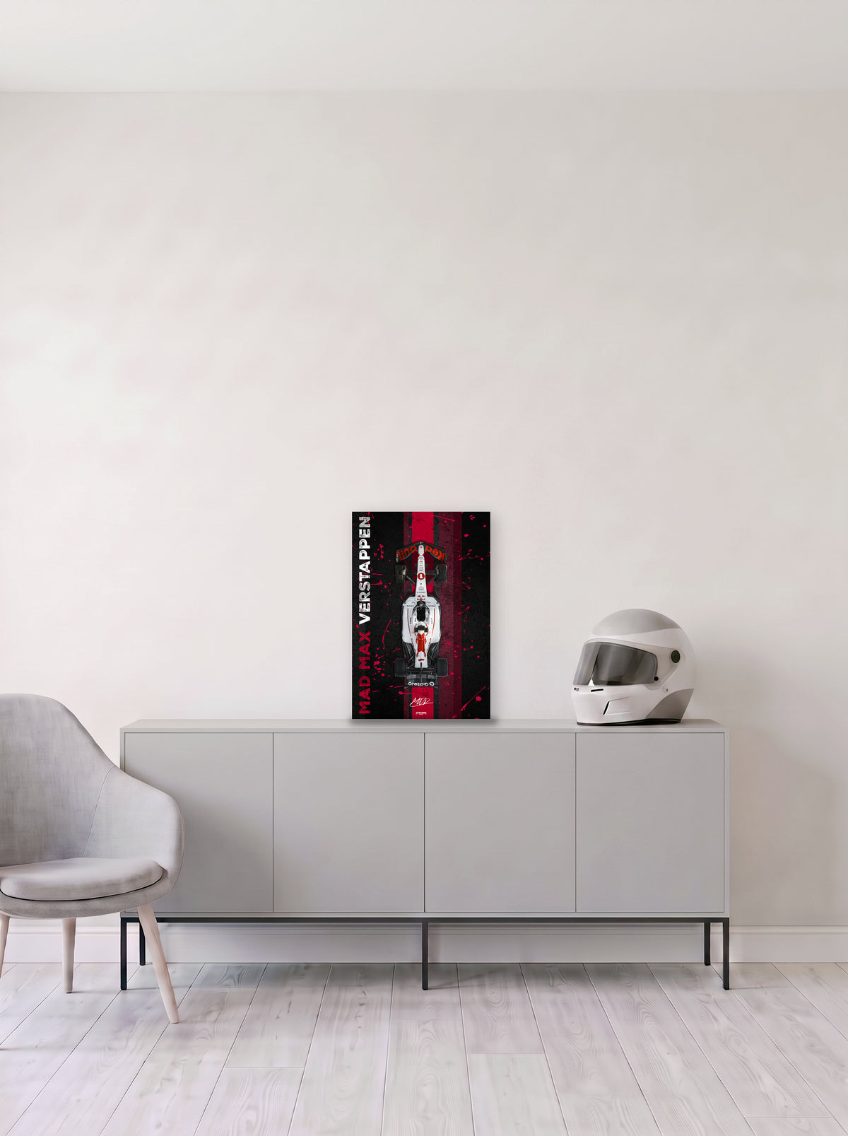 Poster del Red Bull de Max Verstappen con el rotulo Mad Max en vertical sobre franja roja, en medida 33,3 x 50 cm, apoyado sobre un aparador gris junto a un casco de competicion, decoracion racing de MOA-Grafics.