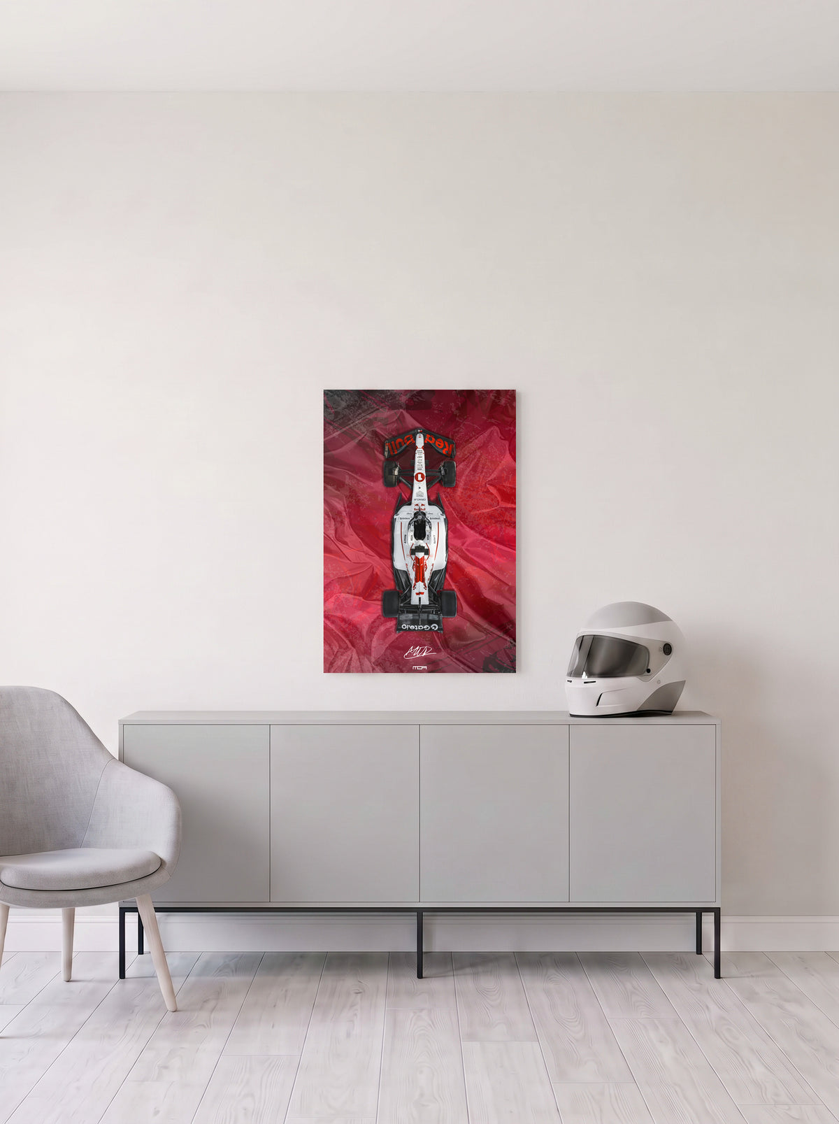 Poster del Red Bull de Max Verstappen sobre fondo rojo satinado, en medida 46,7 x 70 cm, colgado en la pared clara de un salon, sobre un aparador gris con un casco de competicion al lado, decoracion racing de MOA-Grafics.