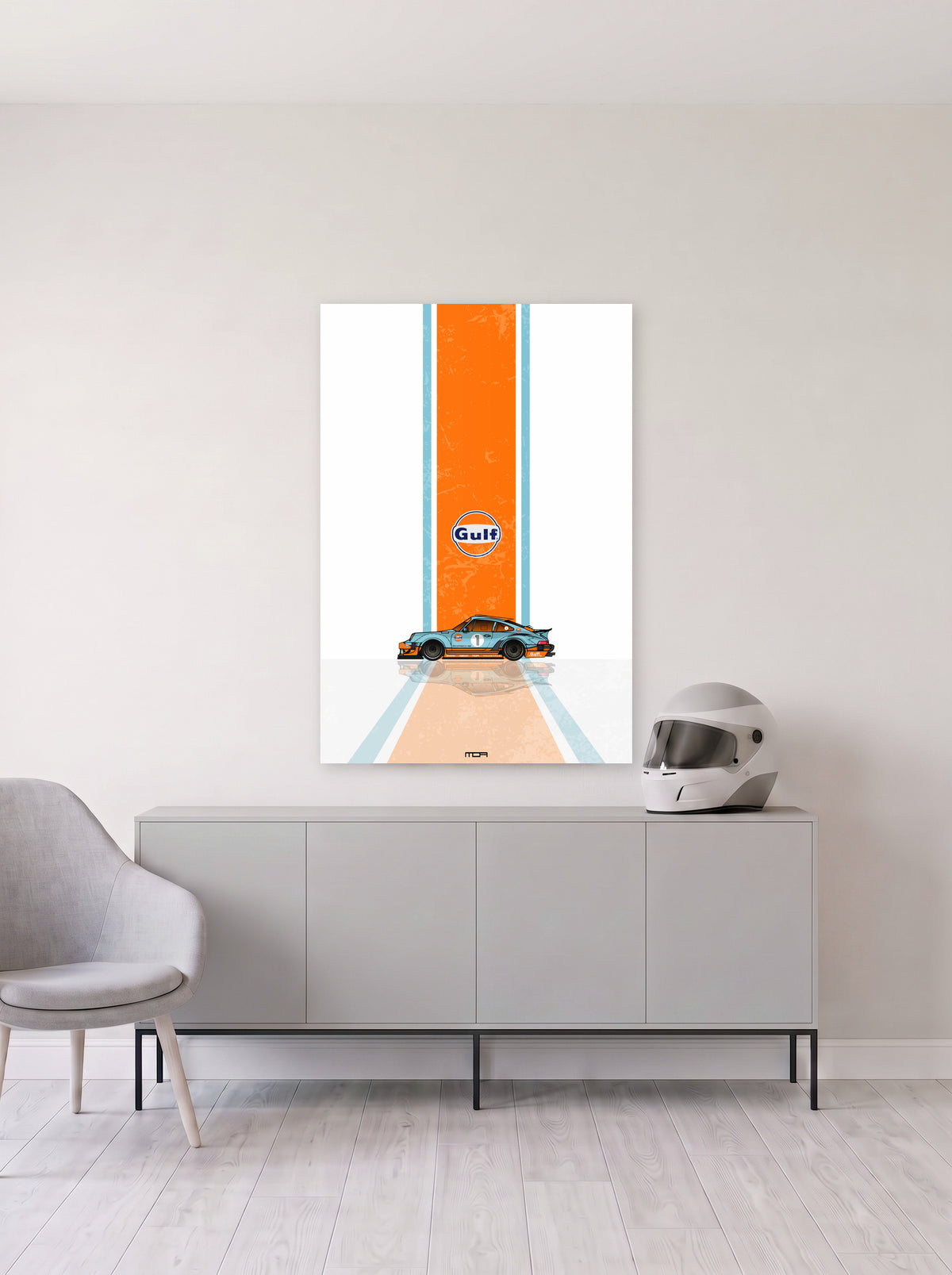 Poster del Porsche 911 Gulf Racing sobre fondo blanco, colgado en la pared clara de un salon, sobre un aparador gris con un casco de competicion al lado, decoracion racing de MOA-Grafics.