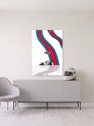Poster del Porsche 911 Martini Racing sobre fondo blanco, colgado en la pared clara de un salon, sobre un aparador gris con un casco de competicion al lado, decoracion racing de MOA-Grafics.