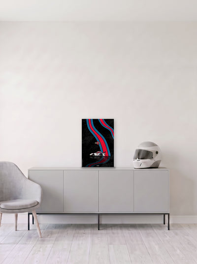 Poster del Porsche 911 Martini Racing sobre fondo negro, en medida 33,3 x 50 cm, apoyado sobre un aparador gris junto a un casco de competicion, decoracion racing de MOA-Grafics.