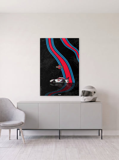 Poster del Porsche 911 Martini Racing sobre fondo negro, colgado en la pared clara de un salon, sobre un aparador gris con un casco de competicion al lado, decoracion racing de MOA-Grafics.