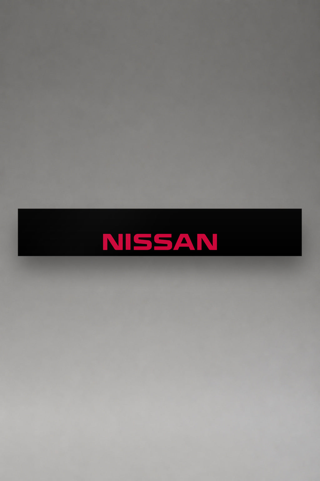 Parasol de vinilo Nissan negro con el logotipo NISSAN en rojo, la tira entera vista de frente, de MOA-Grafics.